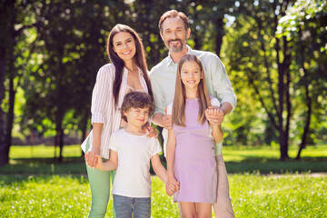 Fototapeta premium Portrait of attractive adorable cheerful family dad daddy hugging mom mommy spending time on fresh air outdoors