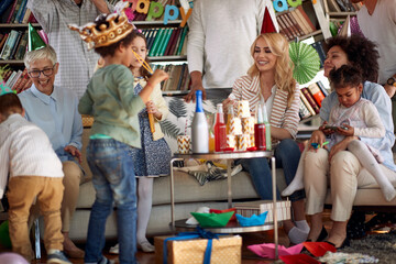 Families enjoy a kids birthday party at home. Family, celebration, together