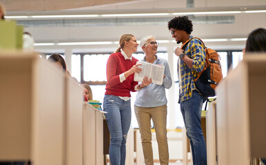 Students asking female professor for some explanations about the lesson