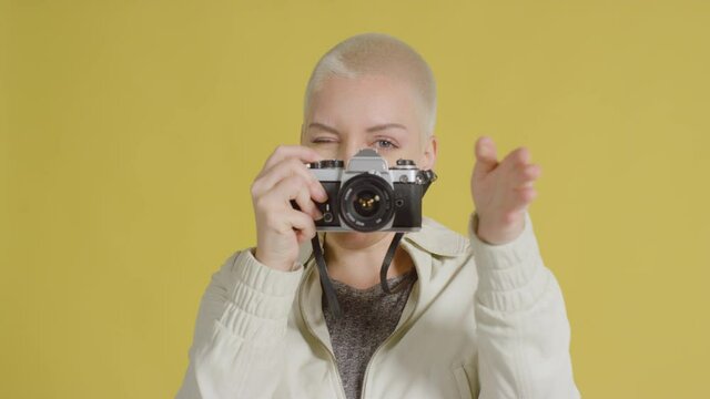 Female caucasian model looking into camera with a vintage SLR 