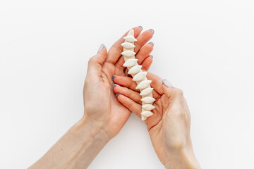 Human spinal column in hands. Spinal health and diseases concept