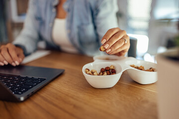 Businesswoman having a snack while working, close-up.