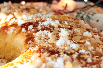 King cake or Roscon de Reyes with black background and christmas lights. Typical spanish dessert for Christmas.