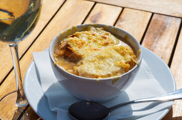 French caramelized onion soup with croutons and gruyere cheesse from oven