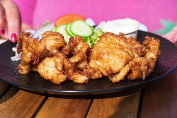 Dutch street food, fried pieces of cod fish fillet served with garlic sauce and fresh green salade