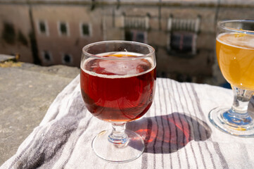 Tasting of Belgian beer on open cafe or bistro terrace with view on medieval houses and canals in Bruges, Belgium