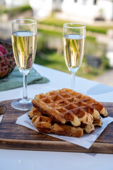 Breakfast with fresh baked belgian waffles and brut champagne sparkling wine in flute glasses...
