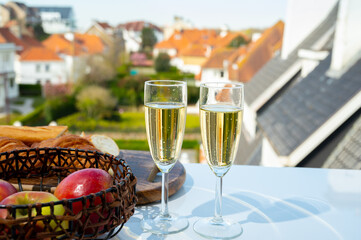 Drinking of brut champagne sparkling wine in flute glasses on outdoor bistro terrace in France