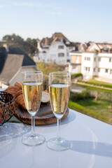 Drinking of brut champagne sparkling wine in flute glasses on outdoor bistro terrace in France