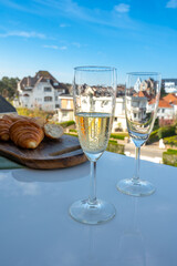 Drinking of brut champagne sparkling wine in flute glasses on outdoor bistro terrace in France
