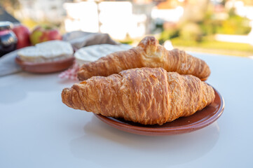 French breakfast with fresh baked croissants and cheeses from Normandy, camembert and neufchatel served outdoor with nice city view