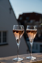 Drinking of rose champagne sparkling wine from flute glasses on outdoor terrace in France