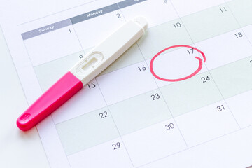 Calendar with pregnancy test, top view. Morherhood and pregnancy concept