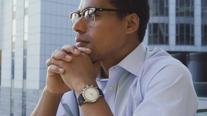 Dreamy man looking at city sunset leaning head on hands and contemplating