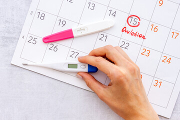 Calendar with hand holding ovulation home test