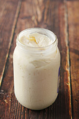 close up of Mayonnaise in container on table .