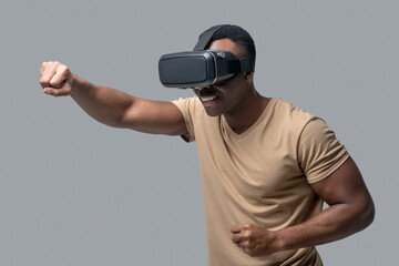 African american young man in vr glasses looking involved