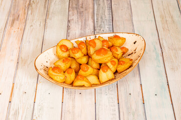 Portion of fried patatas bravas with spicy sauce cooked by a chef in a popular Spanish tapas restaurant
