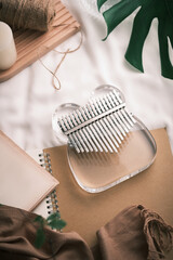 Kalimba or mbira is an African musical instrument on bed. Glass Kalimba with metal, play on hands...