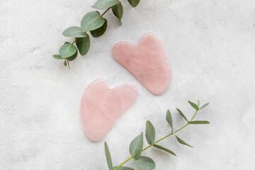 Rose quartz gua sha massage stone with green leaves