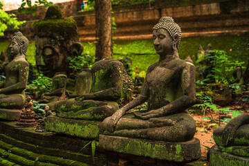 Ancient buddha figures Wat Umong Suan Puthatham is a Buddhist temple in the historic centre and is a Buddhist temple is a major tourist attraction with green forest nature in Chiang Mai,Thailand. - obrazy, fototapety, plakaty