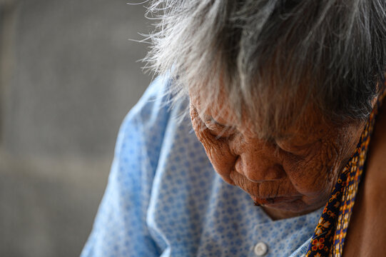 Asian Old Woman Sitting Down Her Face Was Wrinkled And Gray Hair.