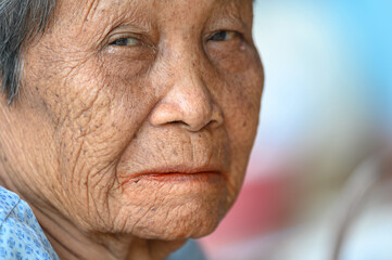 close-up wrinkled old Asian woman's face was smiling happily.Concept: happiness and hope