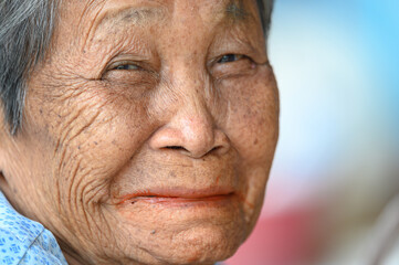 close-up wrinkled old Asian woman's face was smiling happily.Concept: happiness and hope