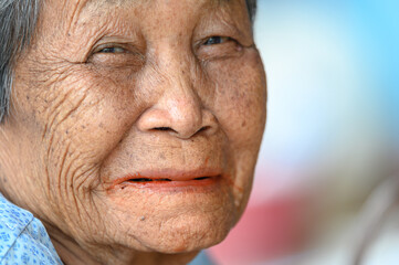 close-up wrinkled old Asian woman's face was smiling happily.Concept: happiness and hope