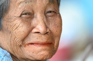 close-up wrinkled old Asian woman's face was smiling happily.Concept: happiness and hope