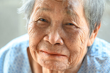 close-up wrinkled old Asian woman's face was smiling happily.Concept: happiness and hope