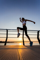 Fitness sport model in fashion sportswear with sunrise sky