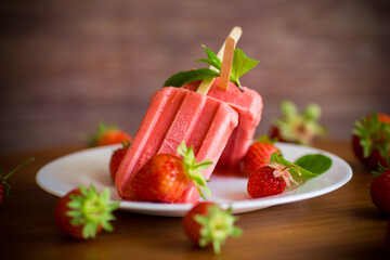 homemade strawberry ice cream on a stick made from fresh strawberries in a plate