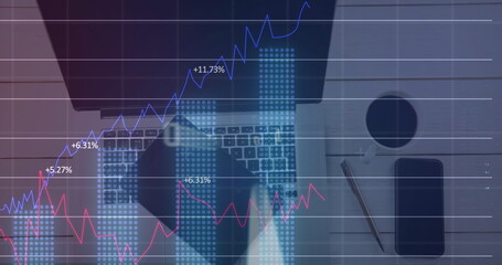 Image of financial data processing over laptop and tablet on desk
