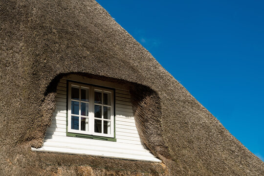 Dachgaube Reet Haus Nordfriesland Deutschland Sylt Nordsee D&auml;nemark traditionell Dachdecker Gras Schilf Handwerk Keitum Sommer blauer Himmel Fenster Aussicht Detail Baustil teuer Schutz Blitzableiter