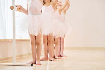 Fototapeta na wymiar Close up view. Little ballerinas preparing for performance by practicing dance moves