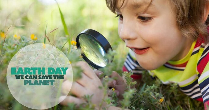 Animation of earth day ecology text and logo over happy boy in nature using magnifying glass