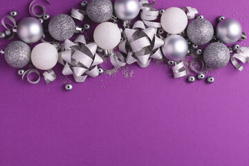 New Year party background with Christmas metallic decorations on purple. Copy space.