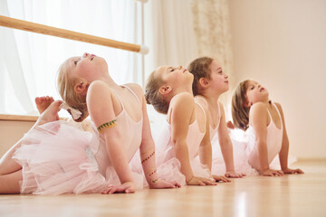 Stretching exercises. Little ballerinas preparing for performance © standret