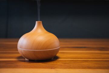 Essential aroma oil diffuser on the wooden table.