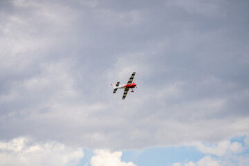 RC propeller aircraft flying on a cloudy sky