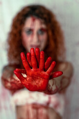 close-up detail of the bloodied hands of a slim girl with curly hair