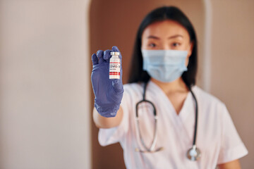 Fototapeta na wymiar COVID-19 vaccine. Young serious asian woman standing indoors
