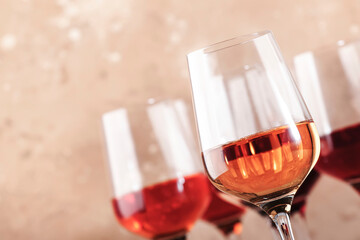 Rose wine glasses on the beige table. Rosado, rosato or blush wine tasting concept, negative space