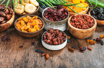Dried fruits bowl. Healthy food snack: sun dried organic mix of apricots, figs, raisins, dates and other on wooden table, top view
