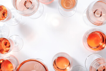 Rose wine glasses on white background. Wine tasting, top view, negative space