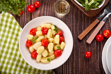Homemade Italian gnocchi with tomato cherry on the wooden table