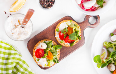 Round crispbread toast with greens and vegetables. Healthy food concept.