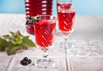 glasses of black currant brandy liqueur with ripe berries