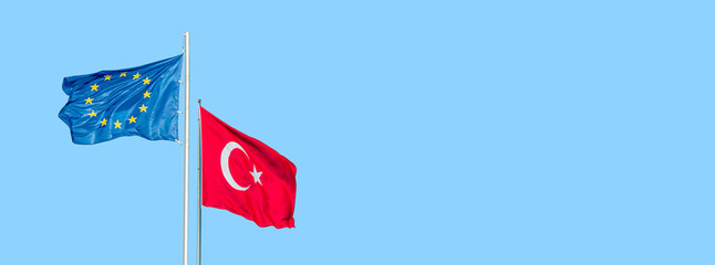 Banner of blue with stars EU flag and red Turkish flag with white crescent moon and star blown at...